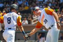 Base runner Skye Bolt (8) is congratulated on a score by Aviators manager Fran Riordan (39) as ...