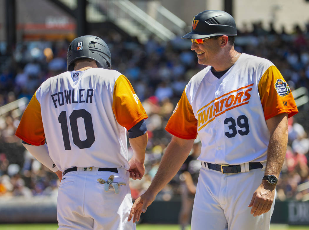 Base runner Skye Bolt (8) is congratulated by Aviators manager Fran Riordan (39) as he makes it ...