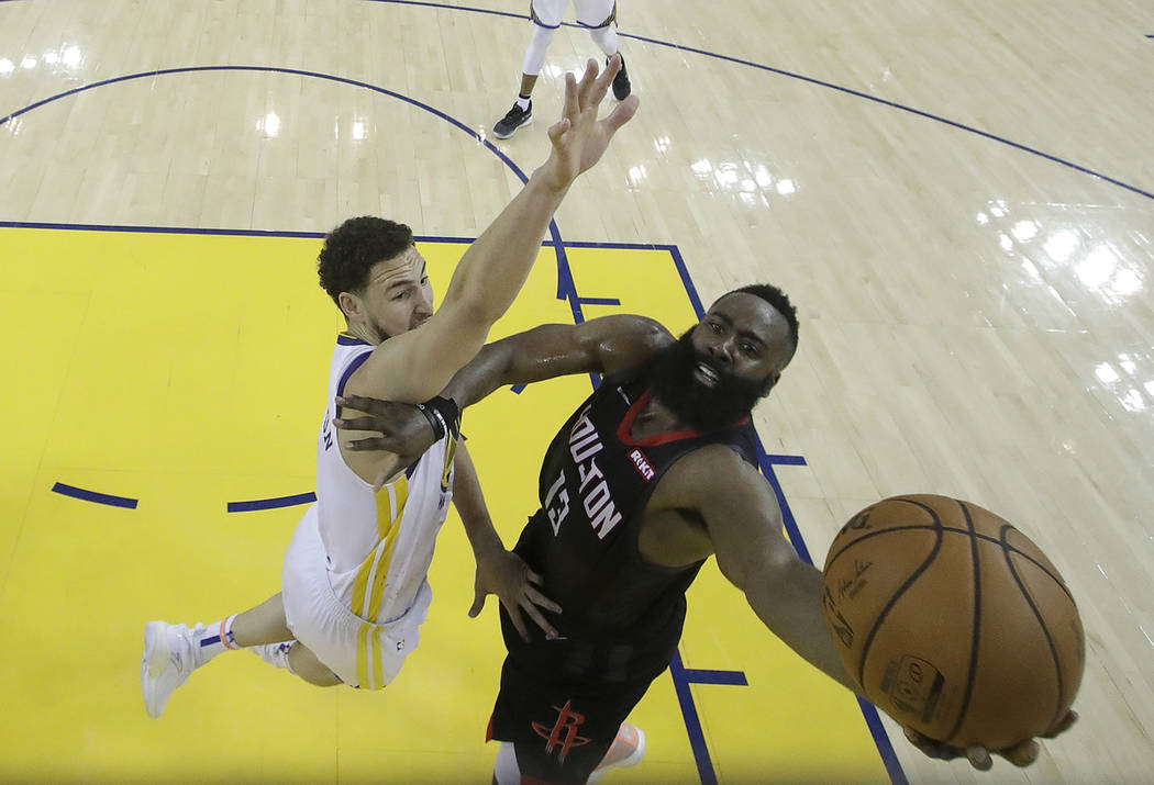 Houston Rockets guard James Harden, right, shoots against Golden State Warriors guard Klay Thom ...