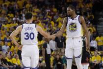 Golden State Warriors guard Stephen Curry (30) reacts with forward Kevin Durant (35) during the ...