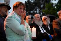 A woman cries during a candlelight vigil held for victims of the Chabad of Poway synagogue shoo ...