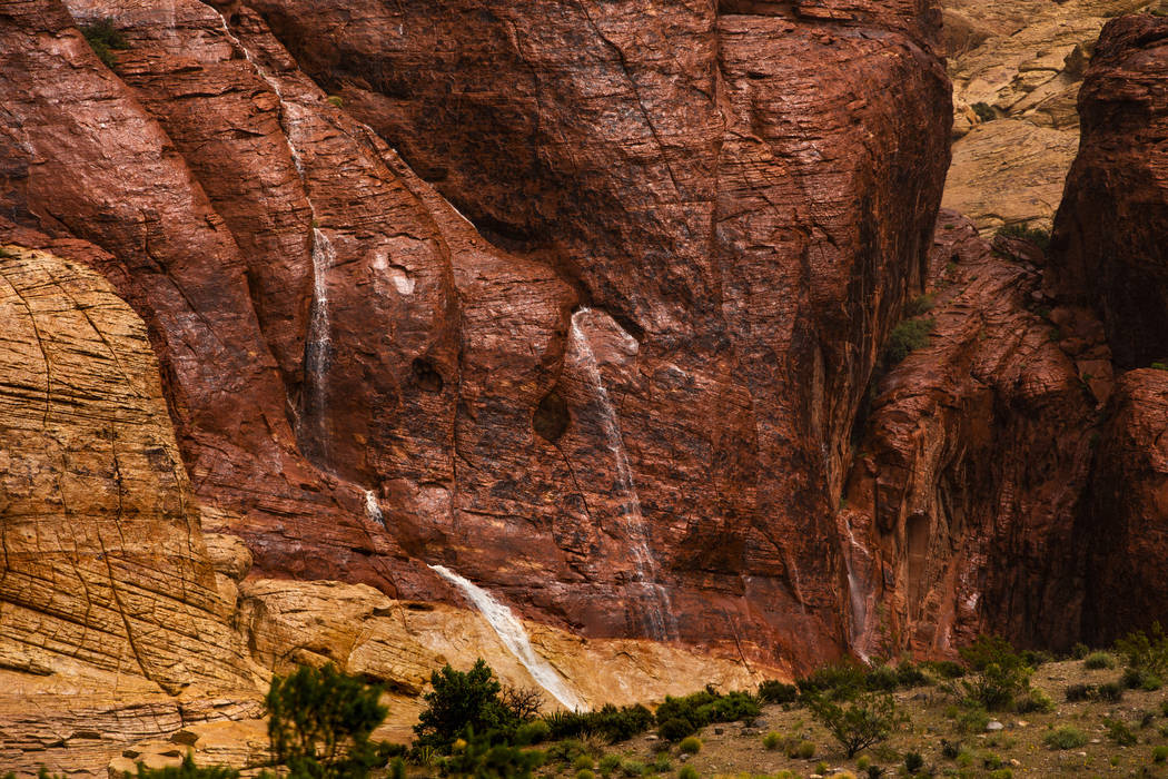 Waterfalls form off the rock wall as a fast-moving storm makes its way through the Red Rock Can ...