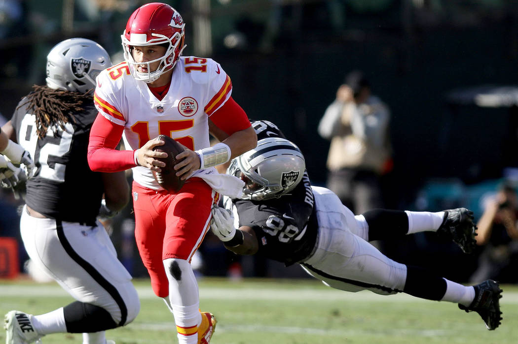 Kansas City Chiefs quarterback Patrick Mahomes (15) sheds tackle by Oakland Raiders defensive e ...