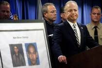United States Attorney Nick Hanna stands next to photos of Mark Steven Domingo, during a news c ...