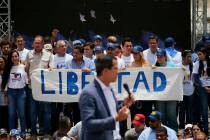 Members of Venezuelan National Assembly holds a sign that reads in Spanish "Freedom" ...