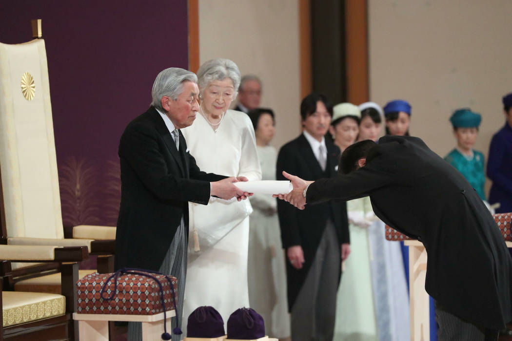 Japan's Emperor Akihito hands over his statement to the grand chamberlain after speaking to oth ...