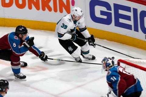 San Jose Sharks center Logan Couture, back right, drives to the net with the puck as Colorado A ...