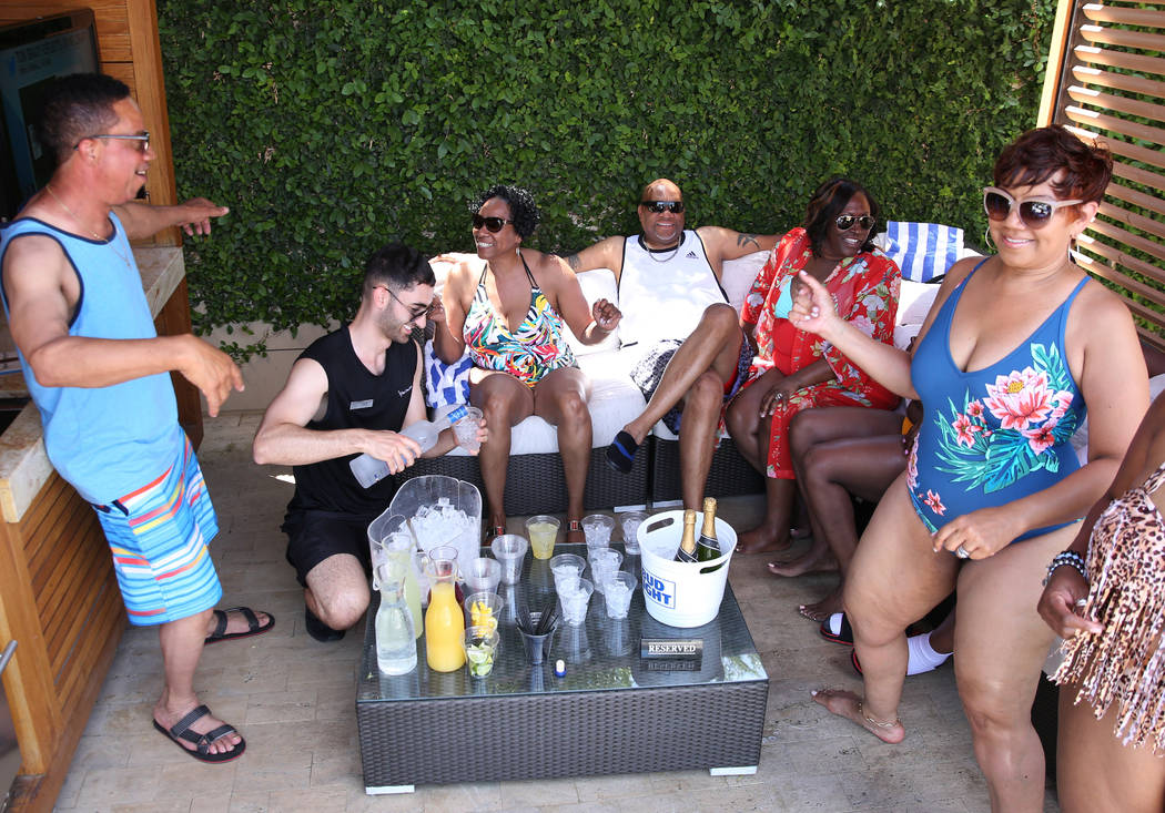 Talih Kadi, model cocktail server, second left, serves drinks to guests at M Resort Spa Casino ...