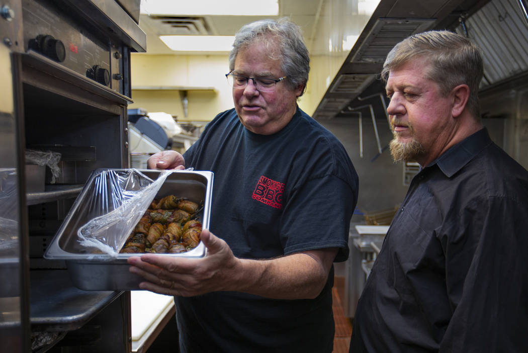 Owner Paul Reddick shows new employee Ron Cochran what they call "wolf turds" in the kitchen at ...