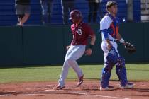 Desert Oasis Parker Schmidt (4) runs home for a run as Bishop Gorman's Gavin Mez (18) looks on ...