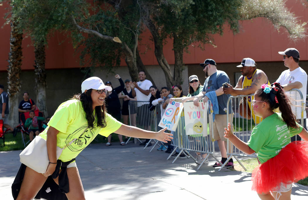 Viveca Grinstead high-fives participants at the Girls on the Run Las Vegas 5K at UNLV in Las Ve ...