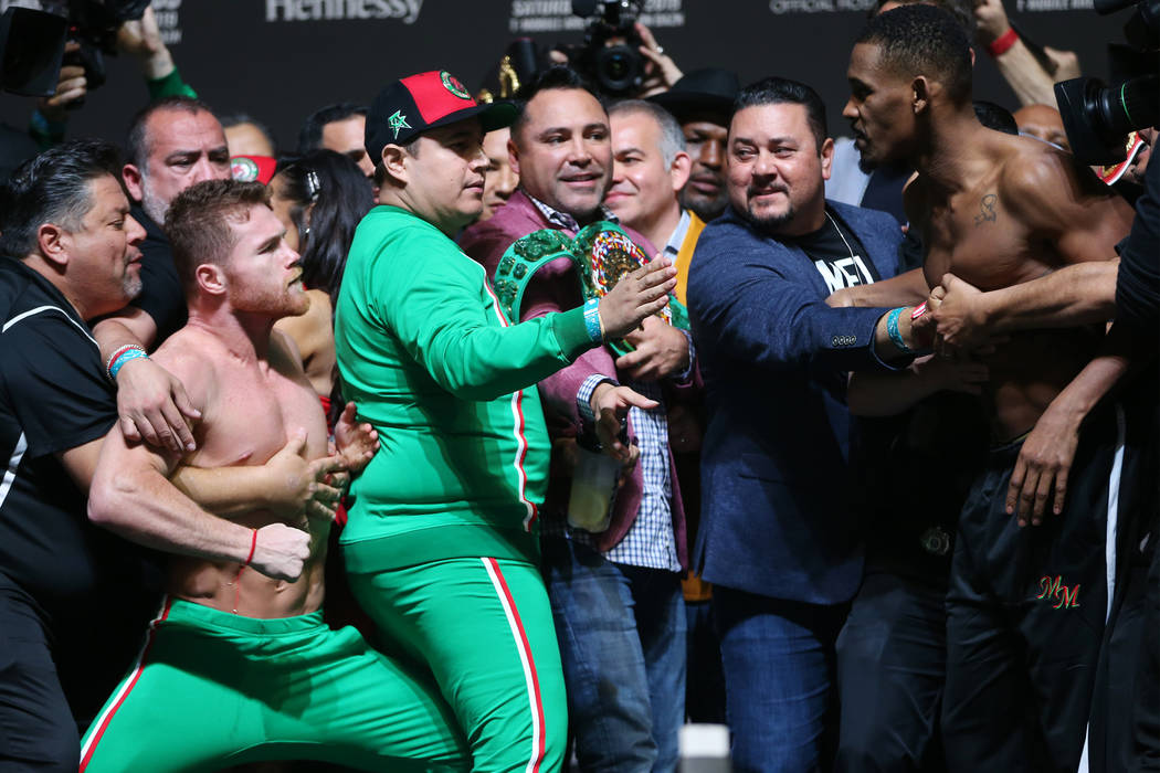 Saul "Canelo" Alvarez, left, and Daniel Jacobs, get into a scuffle during their weigh ...