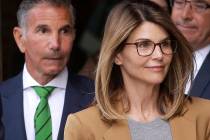 Actress Lori Loughlin, front, and husband, clothing designer Mossimo Giannulli, left, depart fe ...