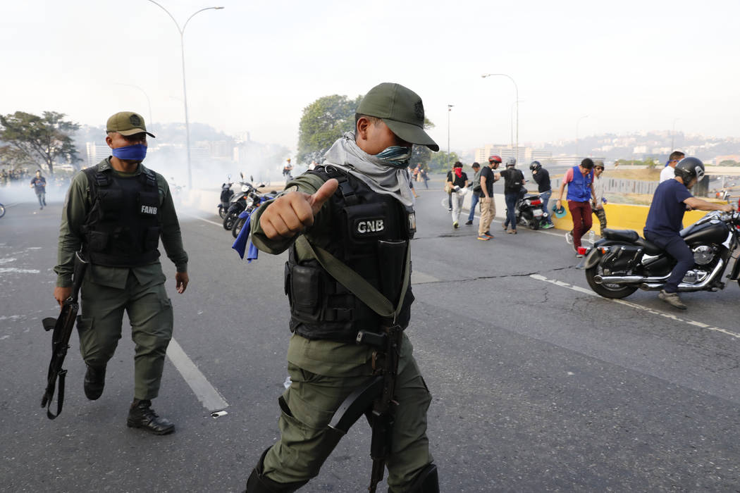 An uprising member of the Bolivarian National Guard gestures outside La Carlota air base in Car ...