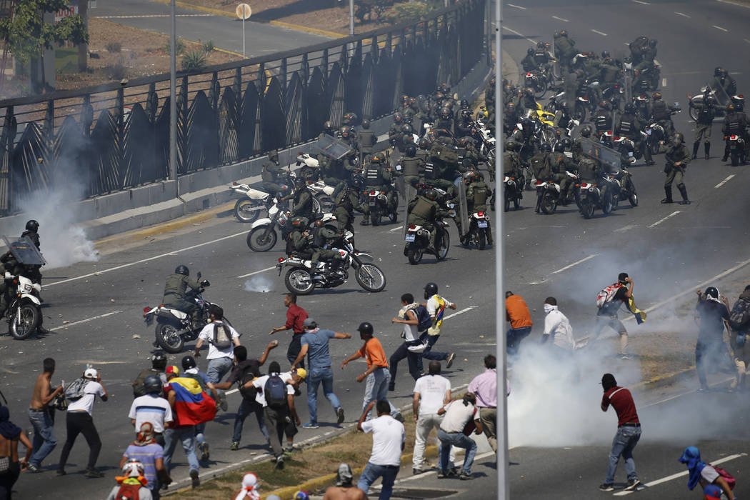 Opponents to Venezuela's President Nicolas Maduro confront loyalist Bolivarian National Guard t ...