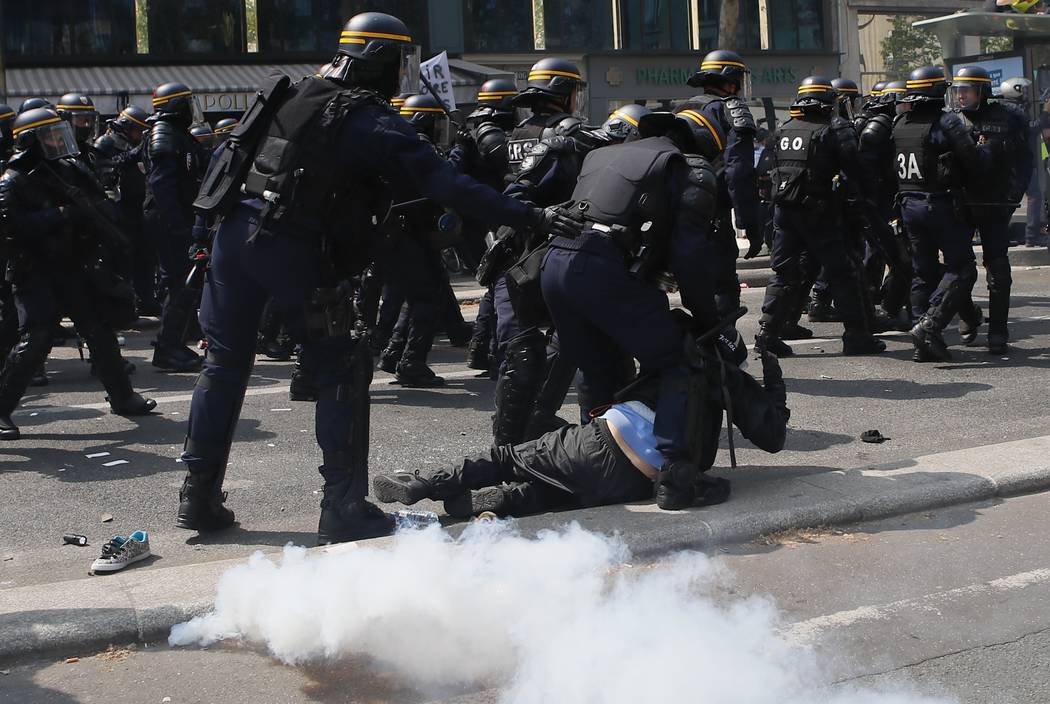 Riot police officers restrain a man during a May Day demonstration in Paris, Wednesday, May 1, ...