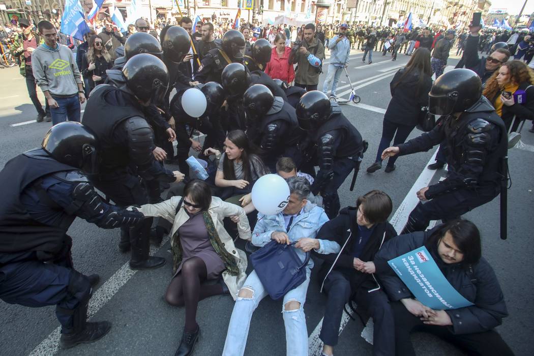 Riot police officers try to detain protesters during a rally in St. Petersburg, Russia, Wednesd ...
