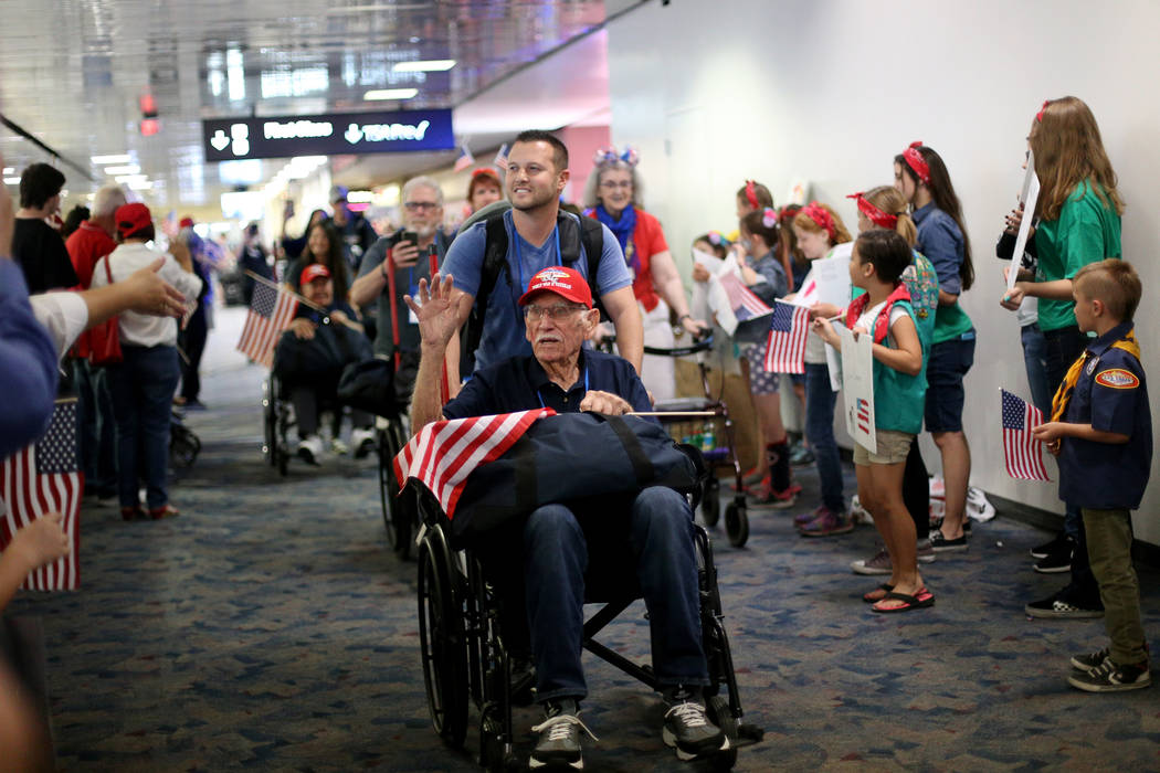 Veteran Dean Whitaker, with guardian Jason Frederico, greets people as they welcome him back fr ...