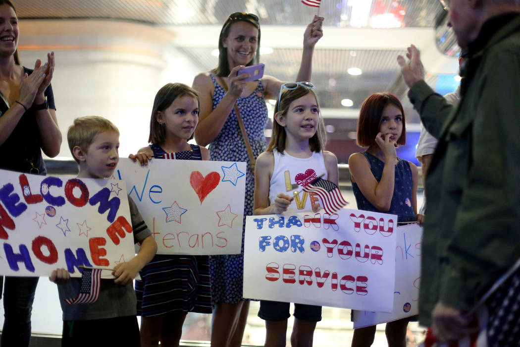 Supporters greet veterans upon their return from a trip to visit the national war memorials in ...