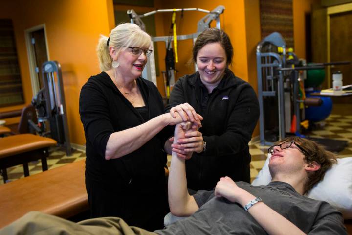 Student physical therapist Meghan Bell, upper right, demonstrates exercises to Kay McClure, lef ...