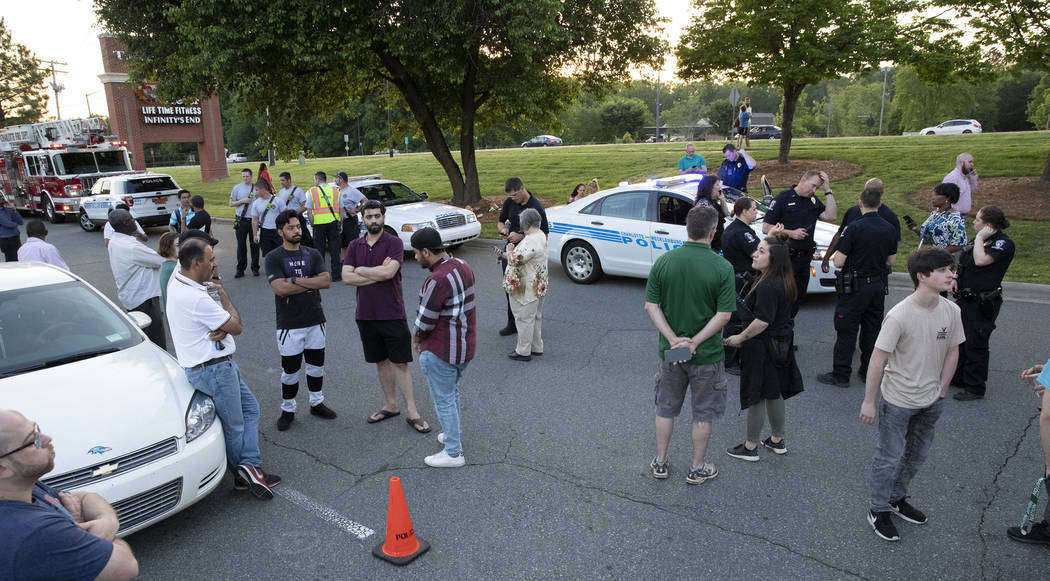 People gather across from the campus of UNC Charlotte after a shooting incident at the school T ...