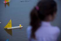 Handmade boats with the names of Nazi concentration camps float in a lake during ceremony marki ...