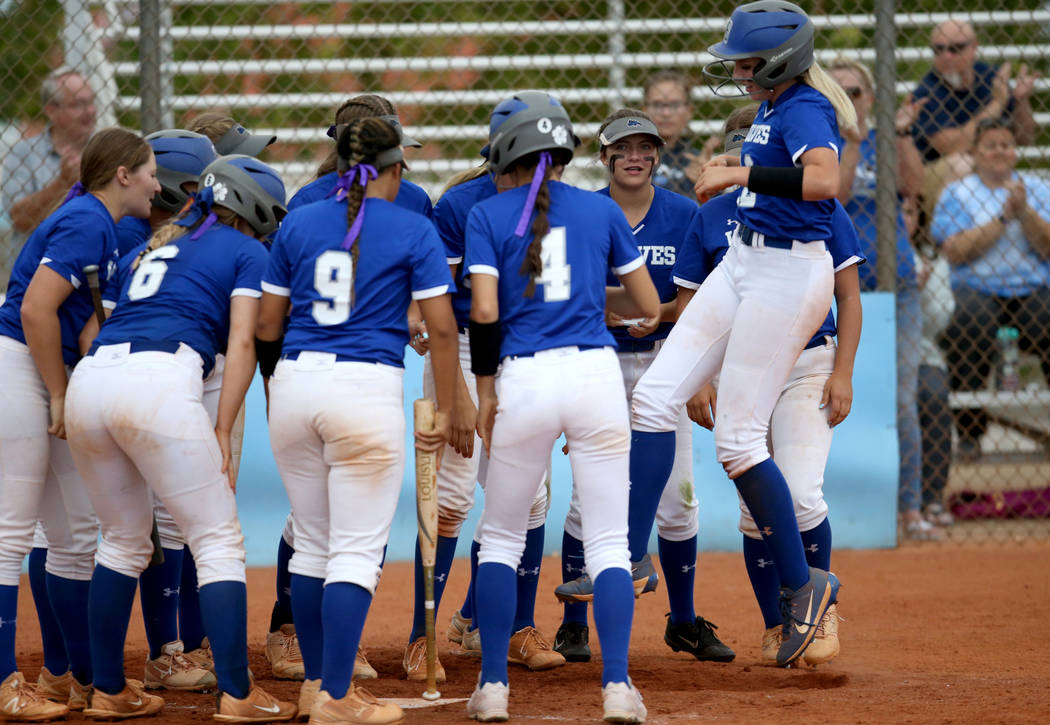 Basic's Sierra McClean (12) hops onto home plate with her teammates in the fourth inning of the ...