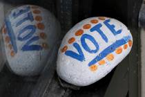 A stone painted with the word "VOTE" rests March 22, 2019, on the window sill of an art gallery ...