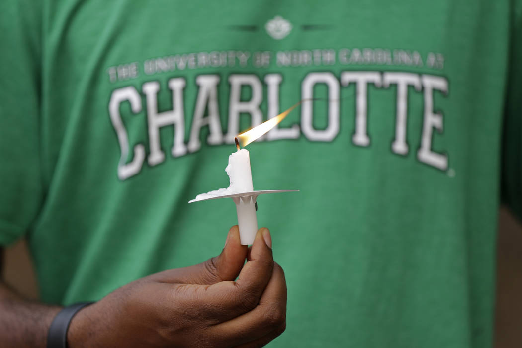 A student holds a candle during a vigil at the University of North Carolina-Charlotte in Charlo ...