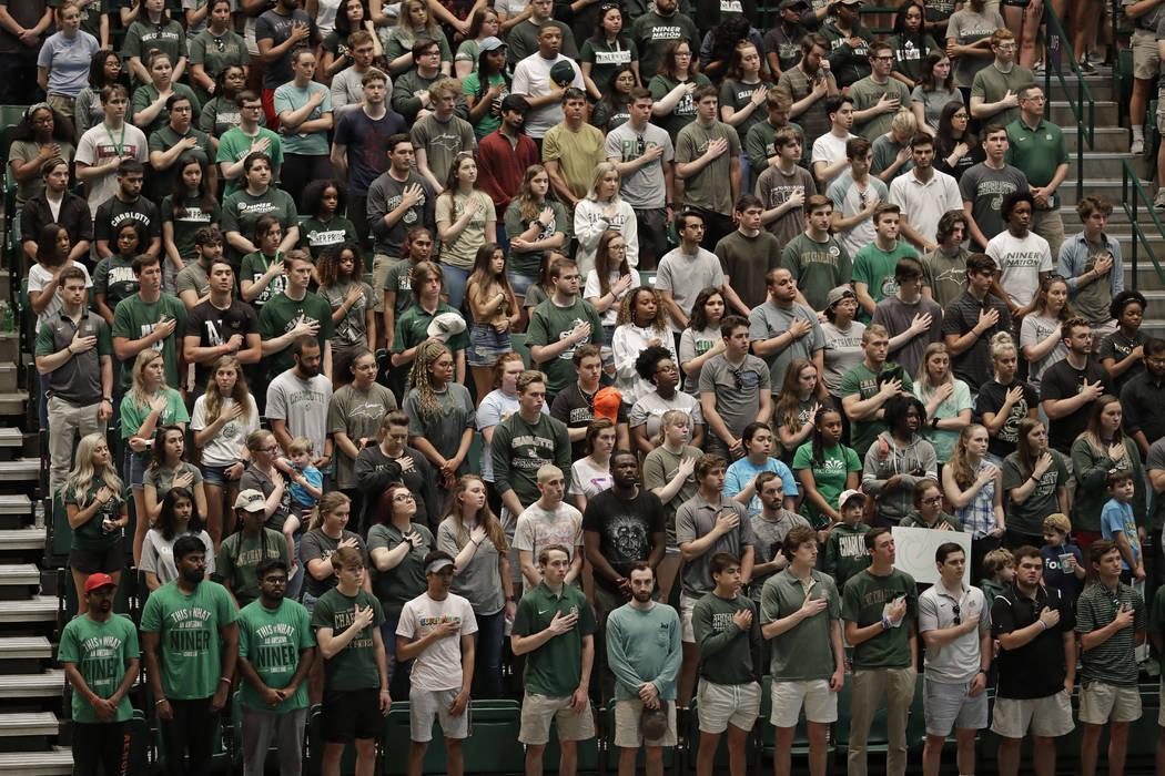 Students stand in Halton Arena during a vigil at the University of North Carolina-Charlotte in ...