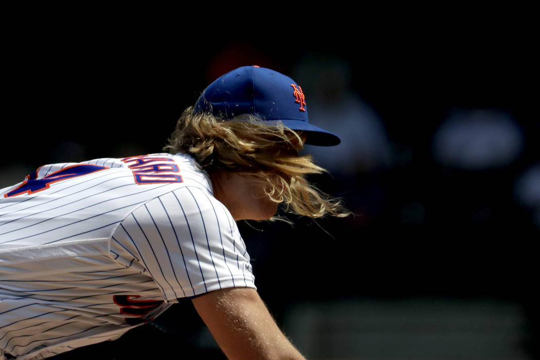 New York Mets starting pitcher Noah Syndergaard's hair flies forward as he pitches to Cincinnat ...
