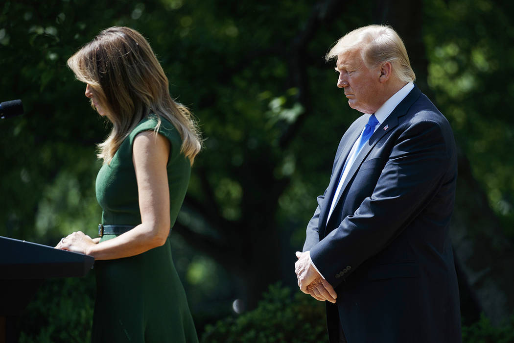 President Donald Trump bows his head as first lady Melania Trump says a prayer during a Nationa ...