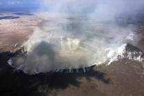 This photo provided by the U.S. Geological Survey shows gases rising from Halemaumau Crater ato ...