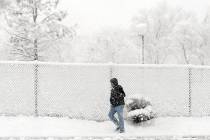 A man walks in the falling snow along a street near downtown Reno on Friday Feb. 18, 2011. (AP ...
