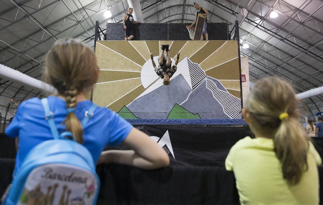 Kids watch Dylan Broadway, middle, with Off Axis Acrobatics, leap on a trampwall during the Las ...