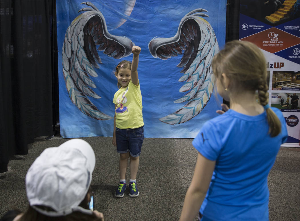 Amber Marica, 7, takes a photo in front of a trick art mural by HeadzUP Vegas during the Las Ve ...