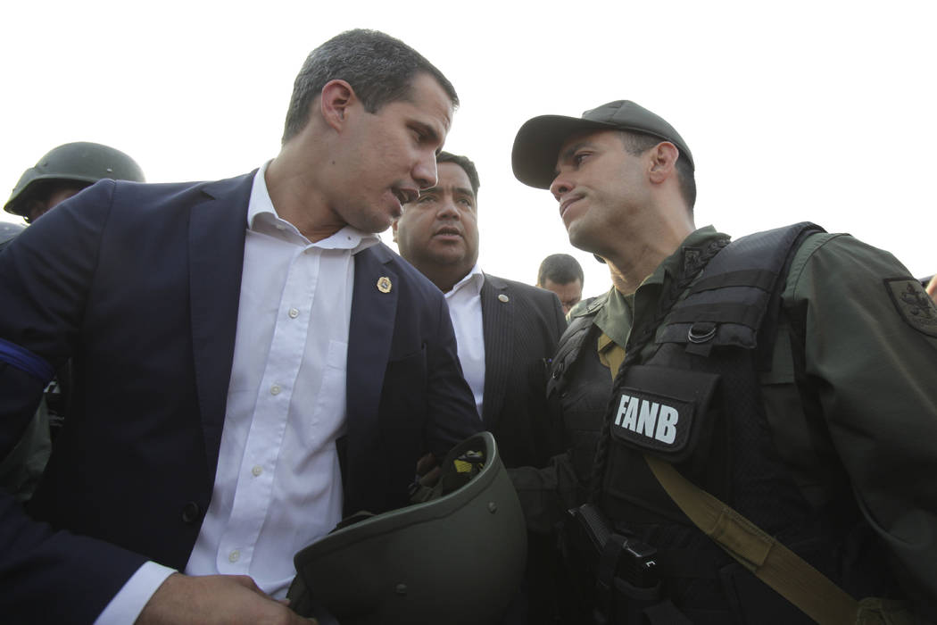 Venezuela's opposition leader and self proclaimed president Juan Guaido talks to an Army office ...