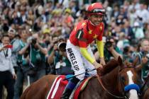 Jockey Mike Smith celebrates riding Justify to win the 150th running of the Belmont Stakes and ...