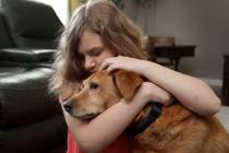 Sobie Cummings, 11, plays with her dog, Dallas, at the family's home in Waxhaw, N.C., on Friday ...