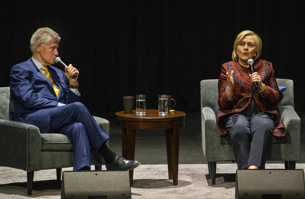 Former U.S. President Bill Clinton looks to former U.S. Secretary of State Hillary Clinton who ...