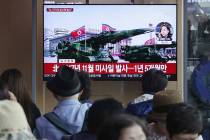 People watch a TV showing a file footage of North Korea's missiles during a military parade in ...