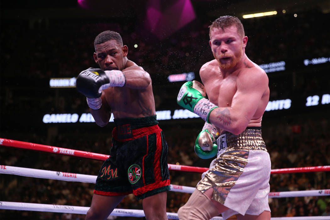 Daniel Jacobs, left, throws a punch against Saul “Canelo” Alvarez in the WBC, WBA ...