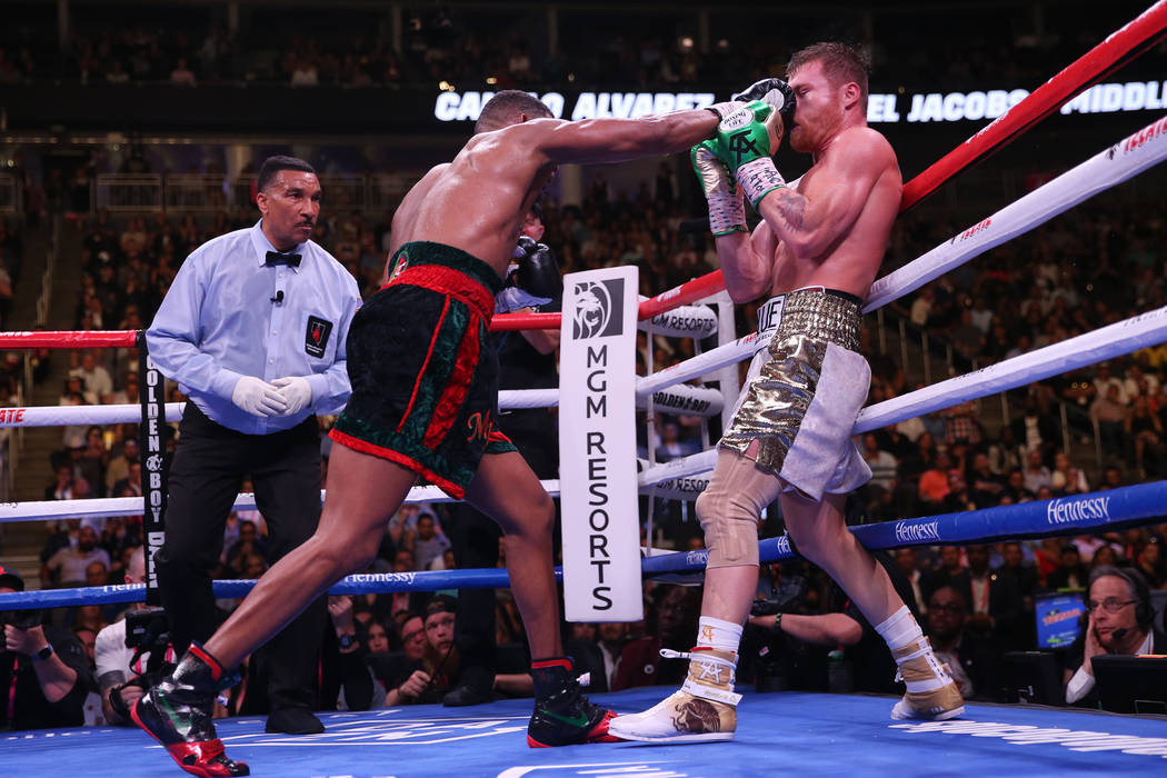 Daniel Jacobs, left, connects a punch against Saul “Canelo” Alvarez in the WBC, W ...