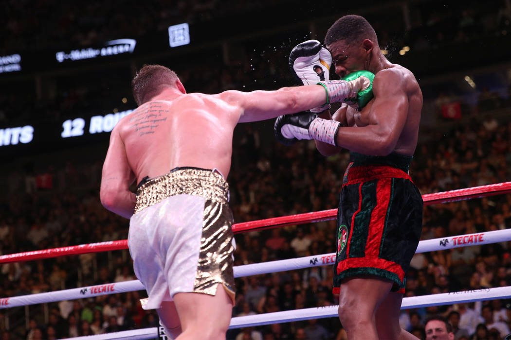 Saul “Canelo” Alvarez, left, connects a punch against Daniel Jacobs in the WBC, W ...