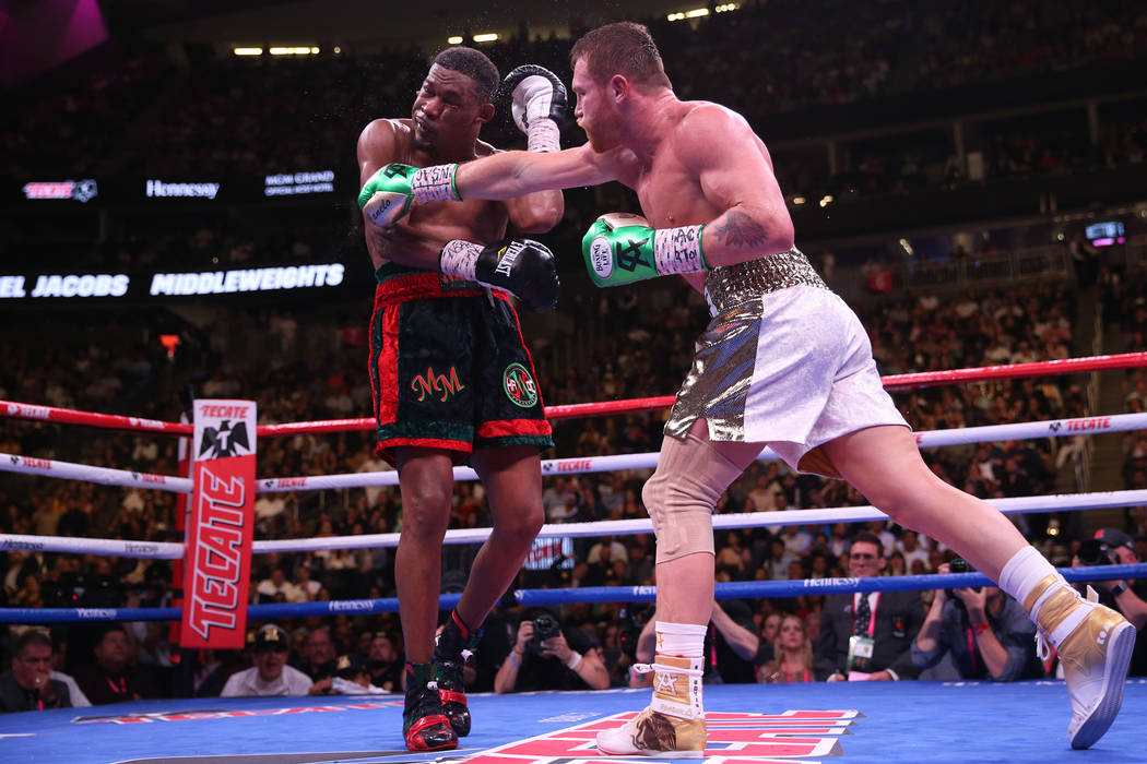Saul “Canelo” Alvarez, right, connects a punch against Daniel Jacobs in the WBC, ...