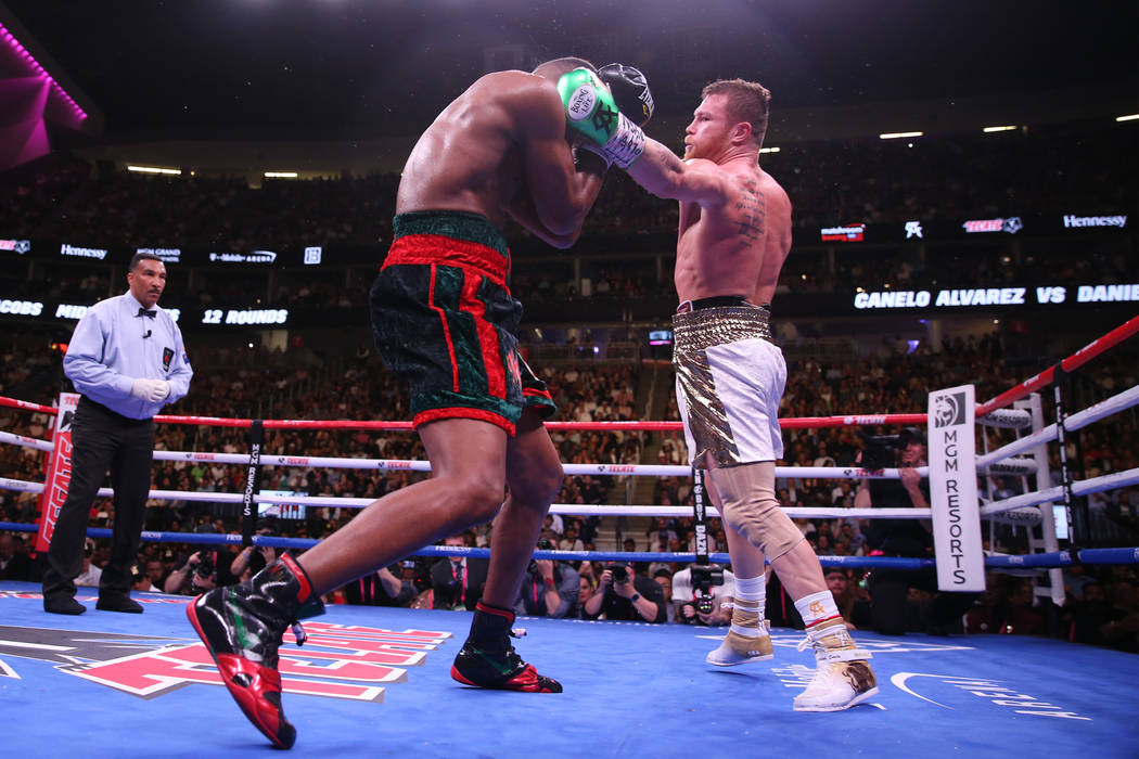 Saul "Canelo" Alvarez, right, throws a punch against Daniel Jacobs in the WBC, WBA, I ...