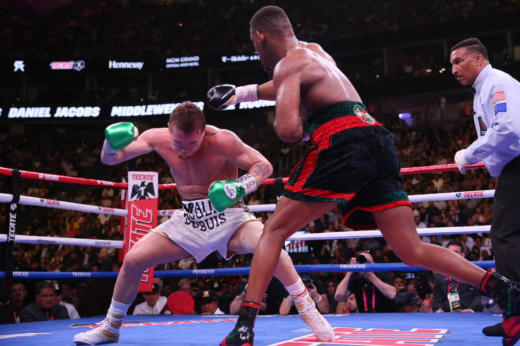 Saul "Canelo" Alvarez, left, moves away from a punch against Daniel Jacobs in the WBC ...