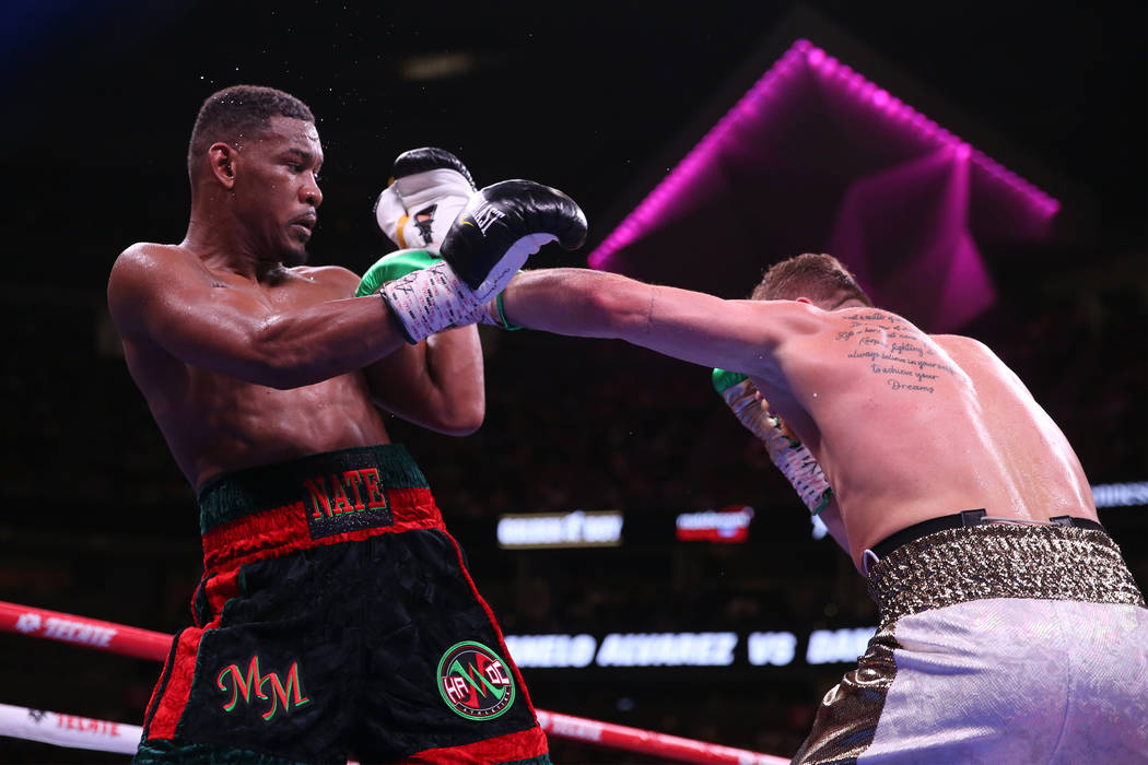 Saul "Canelo" Alvarez, right, throws a punch against Daniel Jacobs in the WBC, WBA, I ...