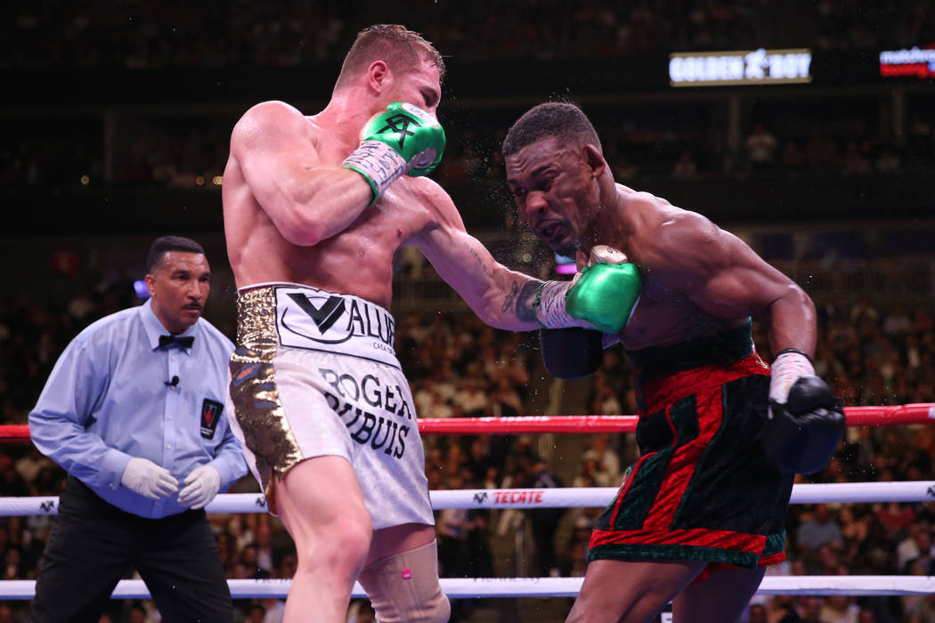 Saul “Canelo” Alvarez, left, connects a punch against Daniel Jacobs in the WBC, W ...