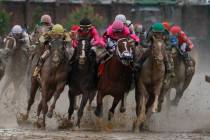 Luis Saez riding Maximum Security, second from right, goes around turn four with Flavien Prat r ...